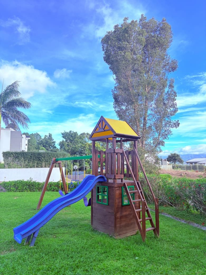 Juegos infantiles con tobogán azul y vista a las montañas
